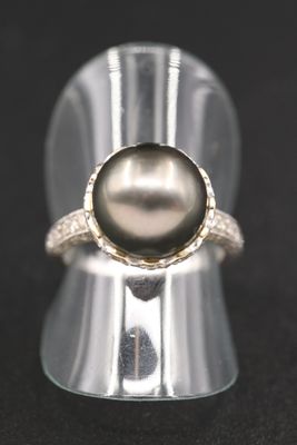 un gros plan d'une bague en argent ornée d'une perle noire