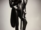 black and white photograph of a woman in a fur coat and leather pants