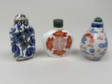 three small chinese vases sitting next to each other on a white surface