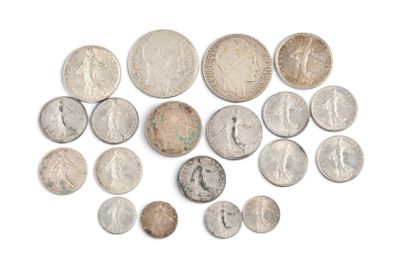 plusieurs types de pièces de monnaie sont disposés sur une surface blanche