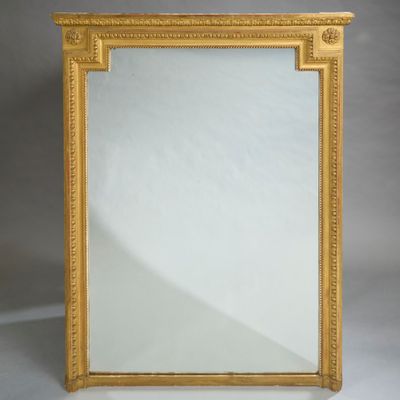 un miroir à cadre doré posé sur une surface blanche, avec un fond blanc