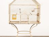une cage blanche avec un oiseau à l'intérieur