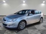 une voiture argentée est garée dans une pièce au sol en damier