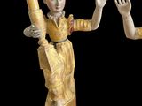 pair of antique figurines of a woman and a man holding a baseball bat