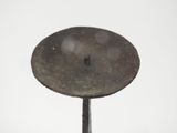 a small metal object on a metal stand on a white surface