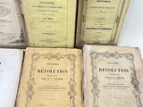 several old books sitting on top of each other on a table