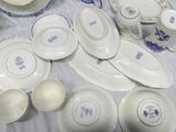 many plates and bowls on a table with a vase