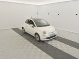 a small white car parked in a room with a black and white checkered floor