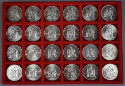 un assortiment de pièces d'argent dans un plateau rouge posé sur une table