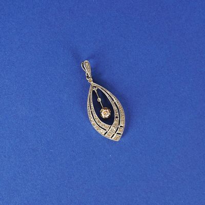 un pendentif en argent orné d'un diamant, sur un fond bleu