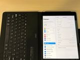 une tablette et un ordinateur portable posés sur un bureau, avec un clavier