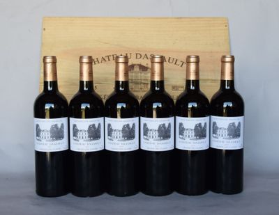 six bouteilles de vin rouge sont posées devant une caisse en bois