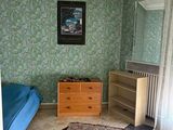 a room with a bed, dresser, and a rug