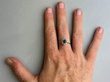 a person ' s hand with a diamond ring on it