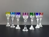 six verres à vin de couleurs différentes alignés sur une table noire