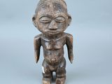 une vieille figurine en bois représentant un homme aux yeux fermés