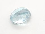 an oval blue topaze stone on a white surface