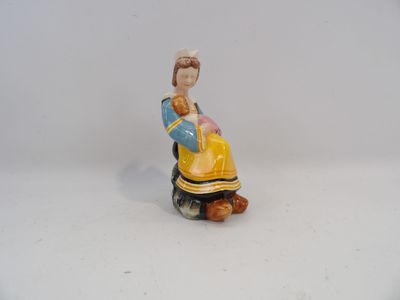 une figurine représentant une femme assise sur un rocher