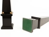 two black and green bookends sitting next to each other on a white surface