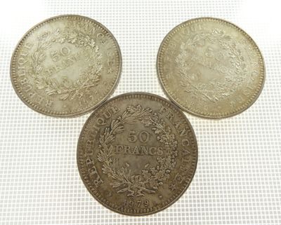 three silver coins sitting on top of each other on a table