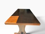 une image représentant une table en bois avec un plateau noir et un piètement marron
