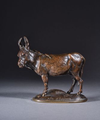 une statue en bronze représentant un âne debout au sommet d'un rocher