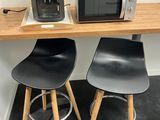 deux tabourets et un micro-ondes posés sur une petite table