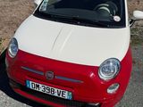 a small red and white car parked on the side of the road