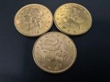 three gold coins, one of which is a sovereign and one of which is a sovereign