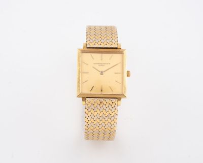 un gros plan d'une montre sur une surface blanche avec un fond blanc