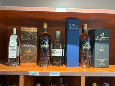 de nombreuses bouteilles d'alcool sur une étagère dans un magasin
