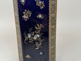 a blue vase with gold and blue flowers on it