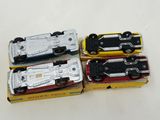 four toy cars that are in a box on a table