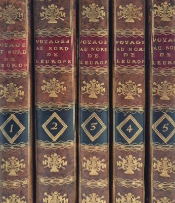several old books are stacked on top of each other in a row
