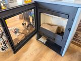 a fireplace in the corner of a kitchen with a glass door