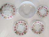 four plates and a bowl sitting on a table