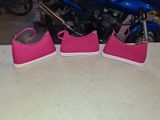 three pairs of pink shoes on a table next to a motorcycle