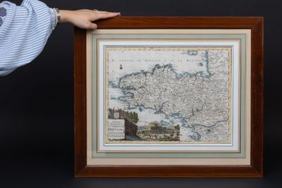 a person holding a framed picture of a map of europe