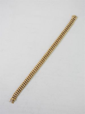 a close up of a gold bracelet on a white surface
