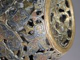 a silver and gold vase with a chain around it