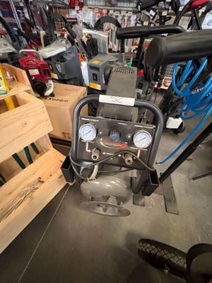 une photo d'un petit compresseur d'air dans un atelier