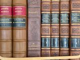 many books that are on a shelf in a library
