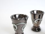 two cups sitting next to each other on a white surface