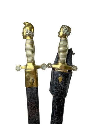two swords that are standing side by side on a white background
