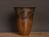 un vase marron posé sur une table en bois