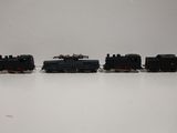 three toy trains are lined up in a row on a white surface