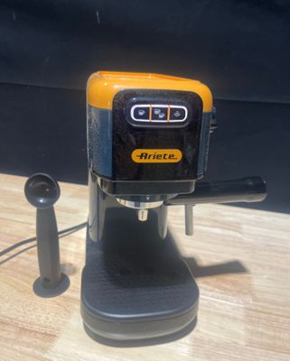 une machine à café jaune et noire posée sur une table en bois