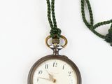 a pocket watch with a chain on a white surface