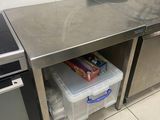 une cuisine équipée d'un plan de travail en inox et d'un micro-ondes