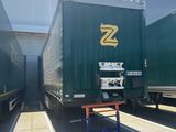 two semi trucks parked next to each other in a warehouse